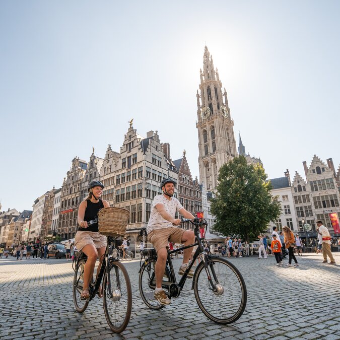 Velofahrer am Grote Markt in Antwerpen vor flämischen Giebelhäusern und dem Turm der Liebfrauenkathedrale. | © Piet de Kersgieter – Antwerpen Grote Markt