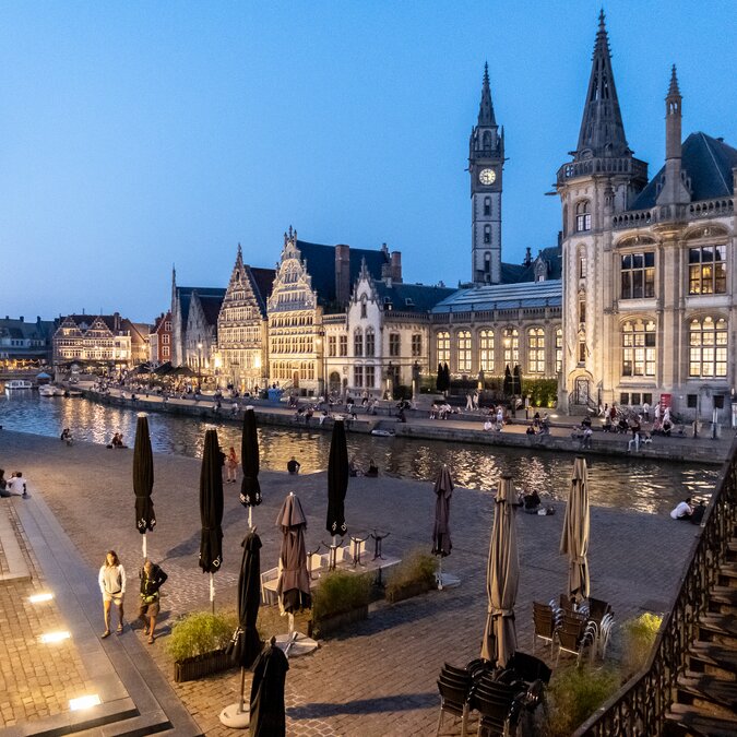 Abendlicher Blick auf die beleuchteten Gildehäuser an der Graslei in Gent mit Flussufer und Menschen. | © Bas van Oort – Gent, Blick auf Graslei