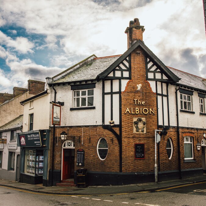 Traditionelles Pub-Haus in Llandudno, Wales, mit markanter Tudor-Fassade, Backsteinarchitektur und charmanter Strassenkulisse in historischer Küstenstadt. | © Crown Copyright (2026) Welsh Government