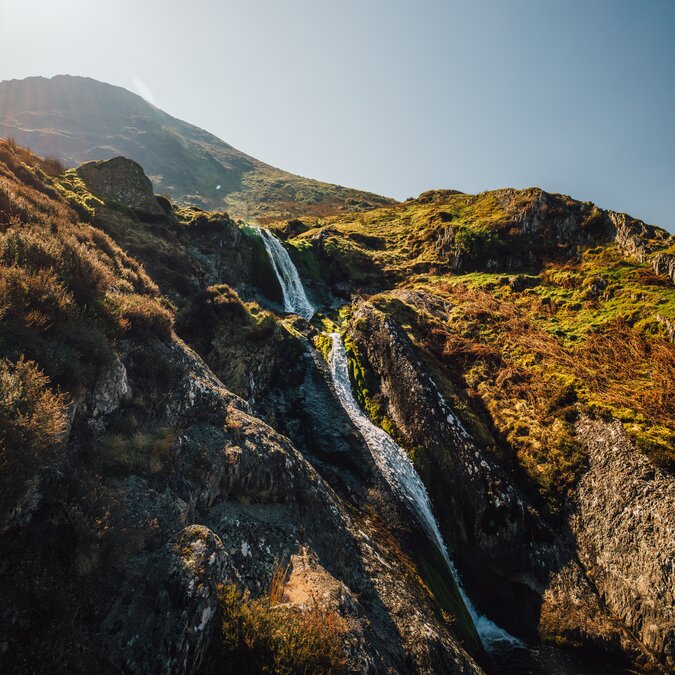 Wasserfall in walisischer Berglandschaft mit felsigem Tal, grünen Hängen und klarem Wasser in unberührter Natur. | © Crown Copyright (2026) Welsh Government