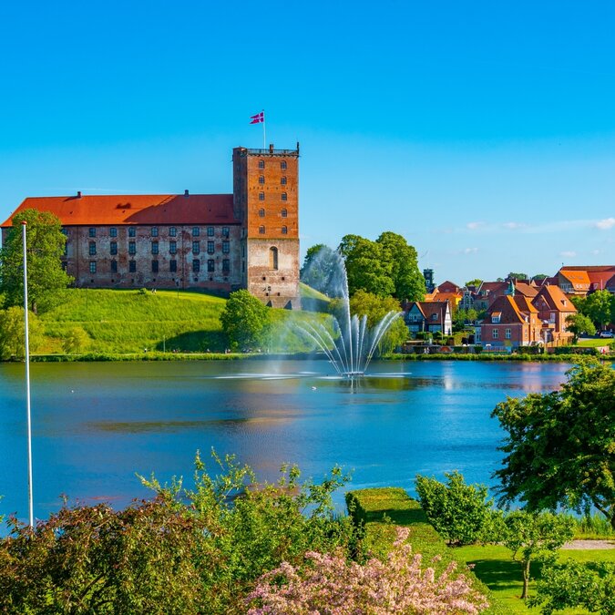Historisches Schloss Koldinghus am idyllischen Schlosssee in Kolding, heute ein Museum mit wechselnden Ausstellungen und kulturellem Treffpunkt | © Shutterstock / 2418519929