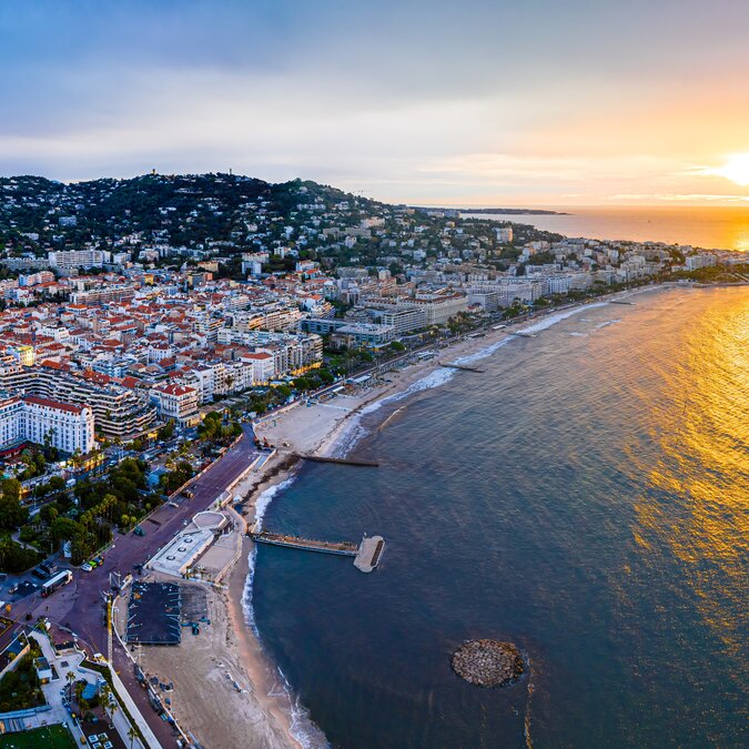 Blick über Cannes bei Sonnenuntergang mit Strand und Küste | © shutterstock_2385346067