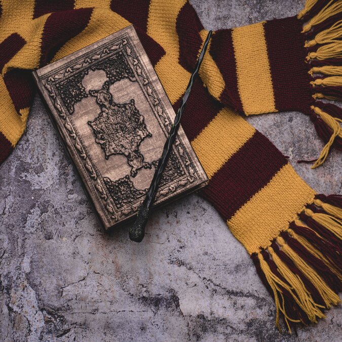 Themen der Zauberschule. Scarf, Zauberstab, Zauberbuch auf grauem Hintergrund | © Shutterstock 1564885576
