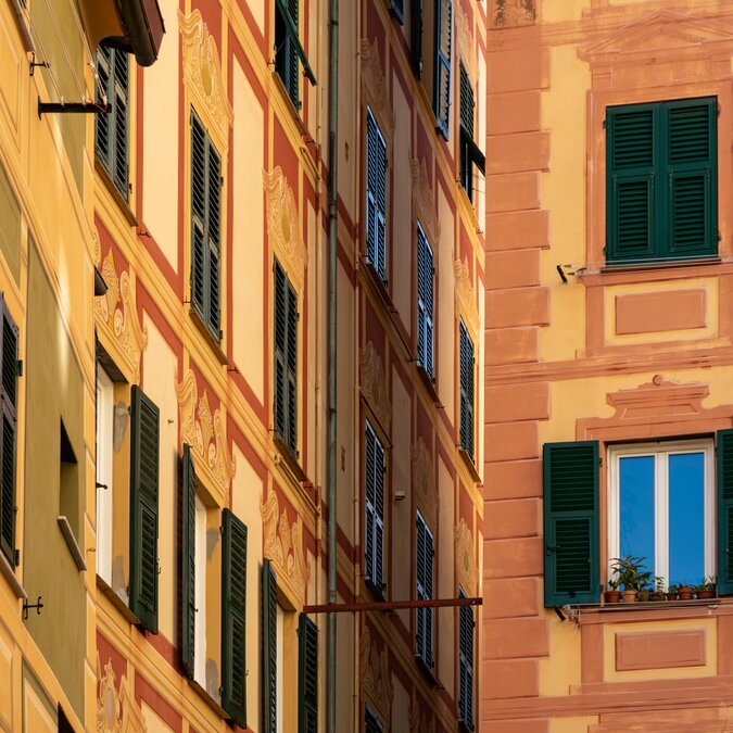 Gelb und orange gefährbte Hausfassaden in Camoglia | © shutterstock / 2463519515