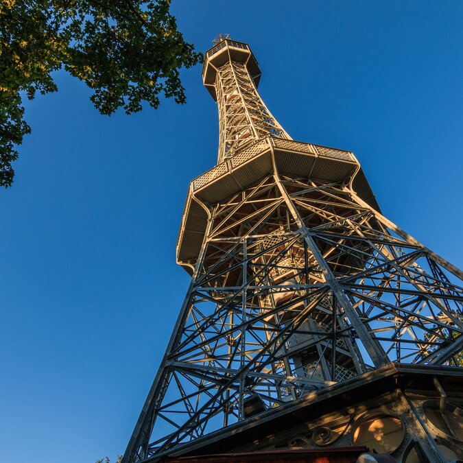 Alter Petrin-Funkturm aus Stahl in Prag auf dem Petrin-Hügel mit Blick vom Sockel im Stadtteil Kleinseite mit Aussichtsplattform bei Sonnenschein und blauem Himmel | © Shutterstock 1534129550